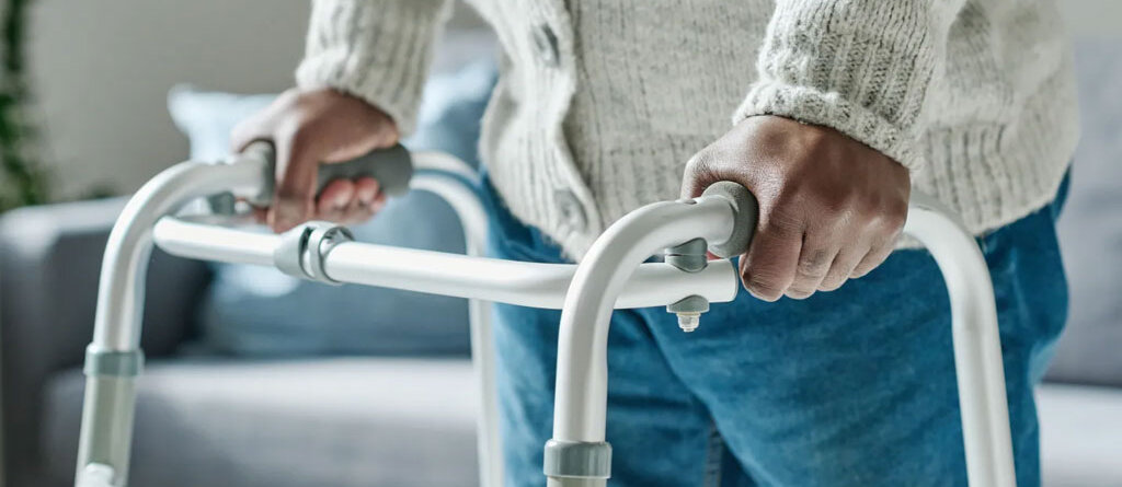 Walker rental Ontario - senior using a folding aluminum walker at home