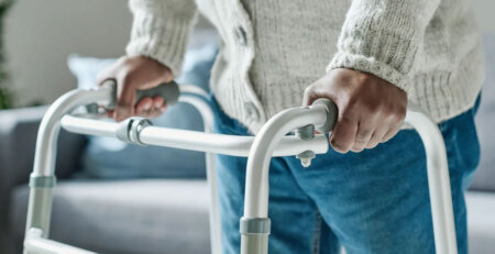 Walker rental Ontario - senior using a folding aluminum walker at home