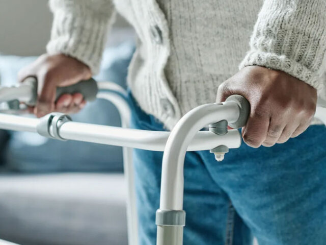 Walker rental Ontario - senior using a folding aluminum walker at home